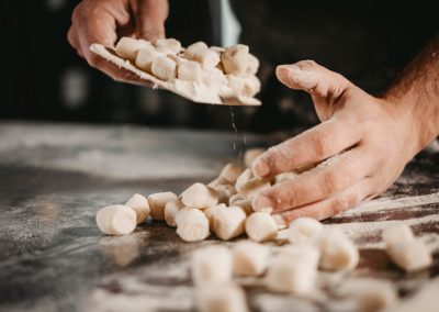 Mani che infarinano gli gnocchi fatti a mano di Ristorante Mangio Roma
