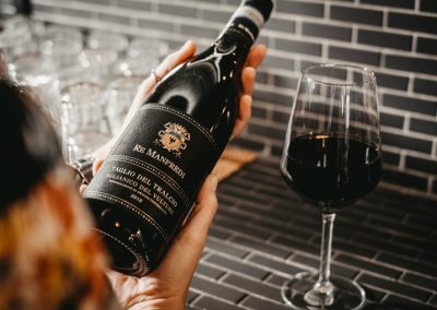 Bottiglia di vino rosso Re Manfredi con un calice di Ristorante Mangio Roma